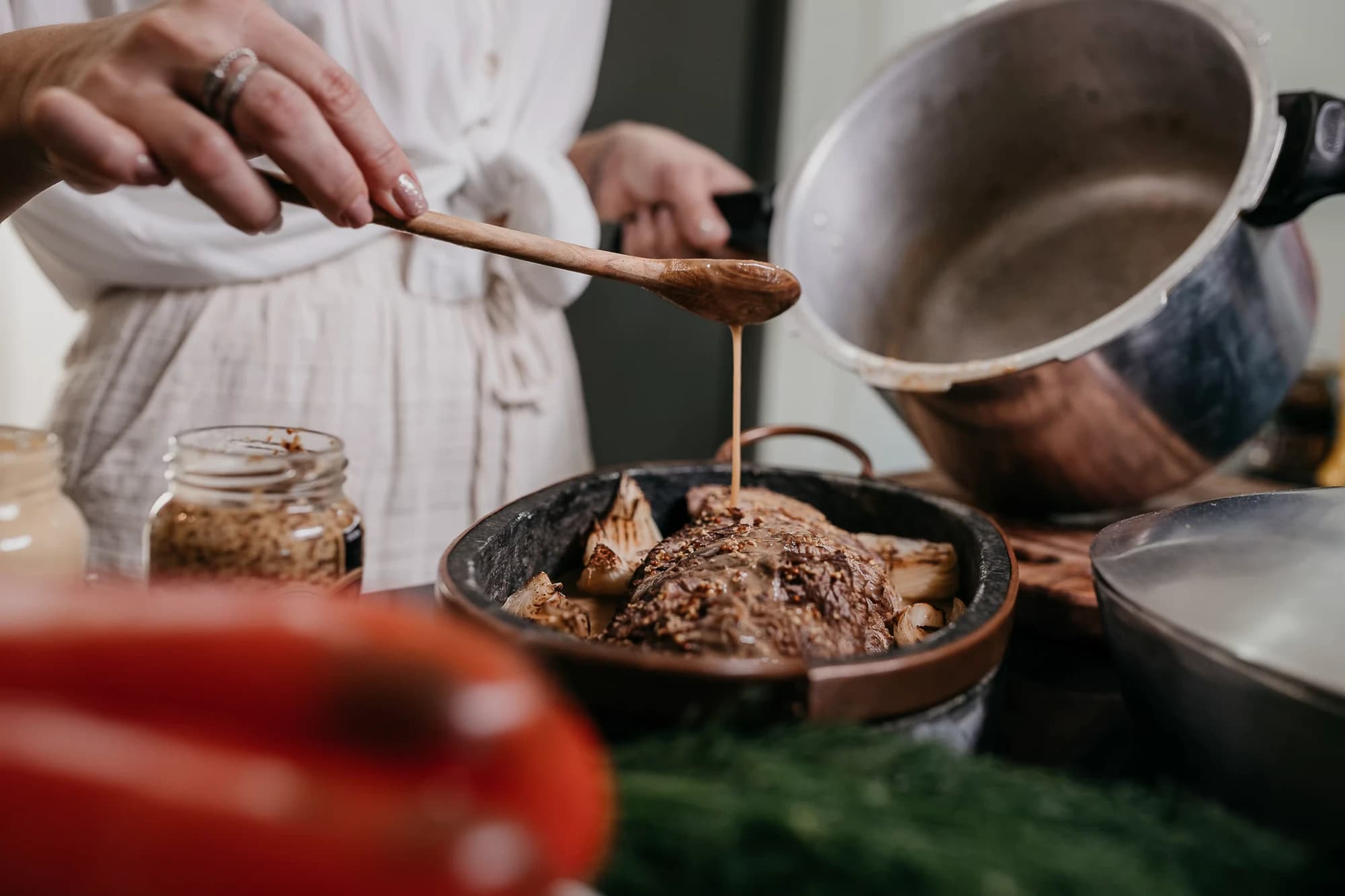 In cucina, il fondo di cottura versato col cucchiaio di legno sull'arrosto
