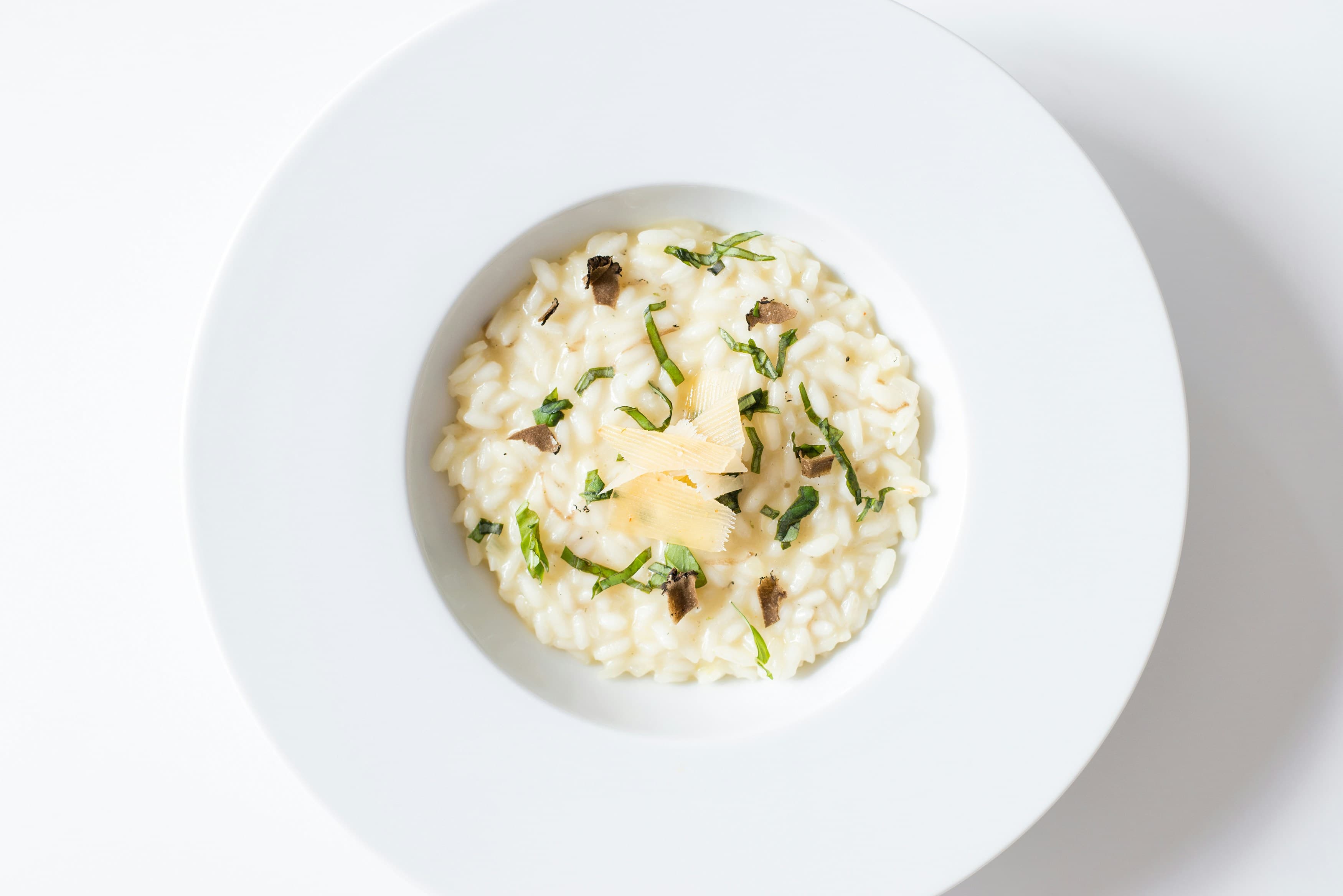 Risotto mantecato servito in un piatto bianco