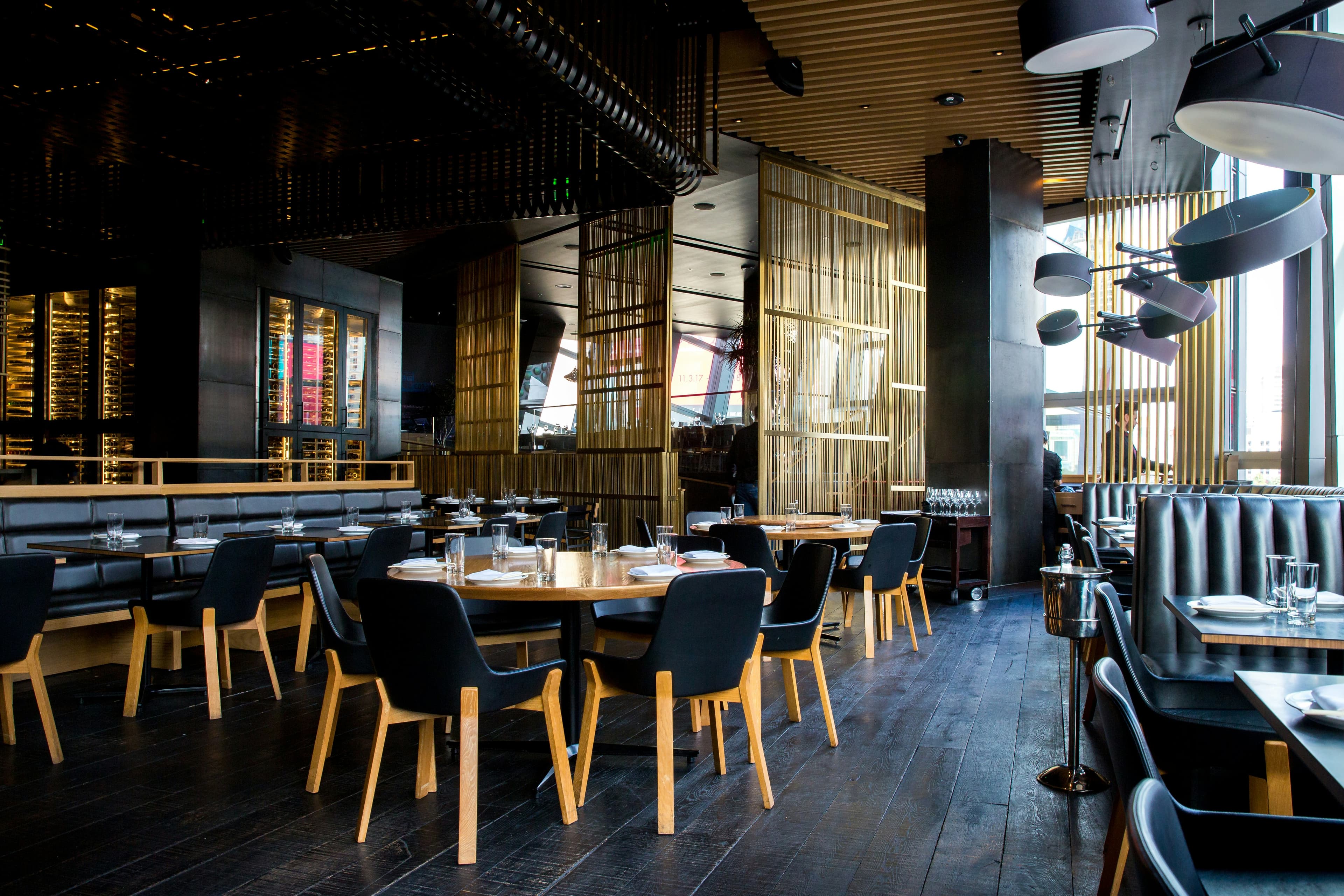 La sala del ristorante con luci soffuse e tavoli in legno scuro