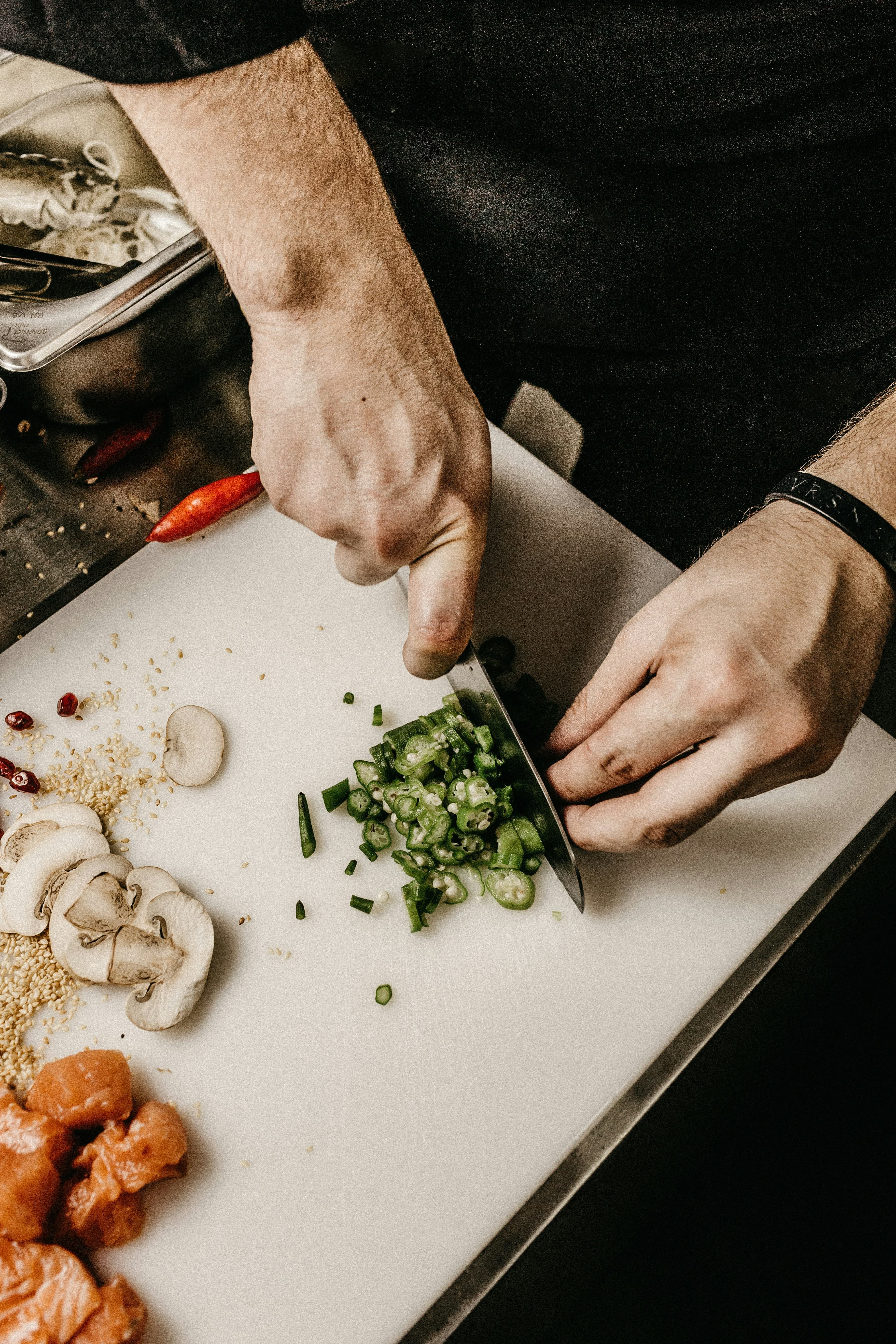 Mani che tagliano erbe fresche sul tagliere